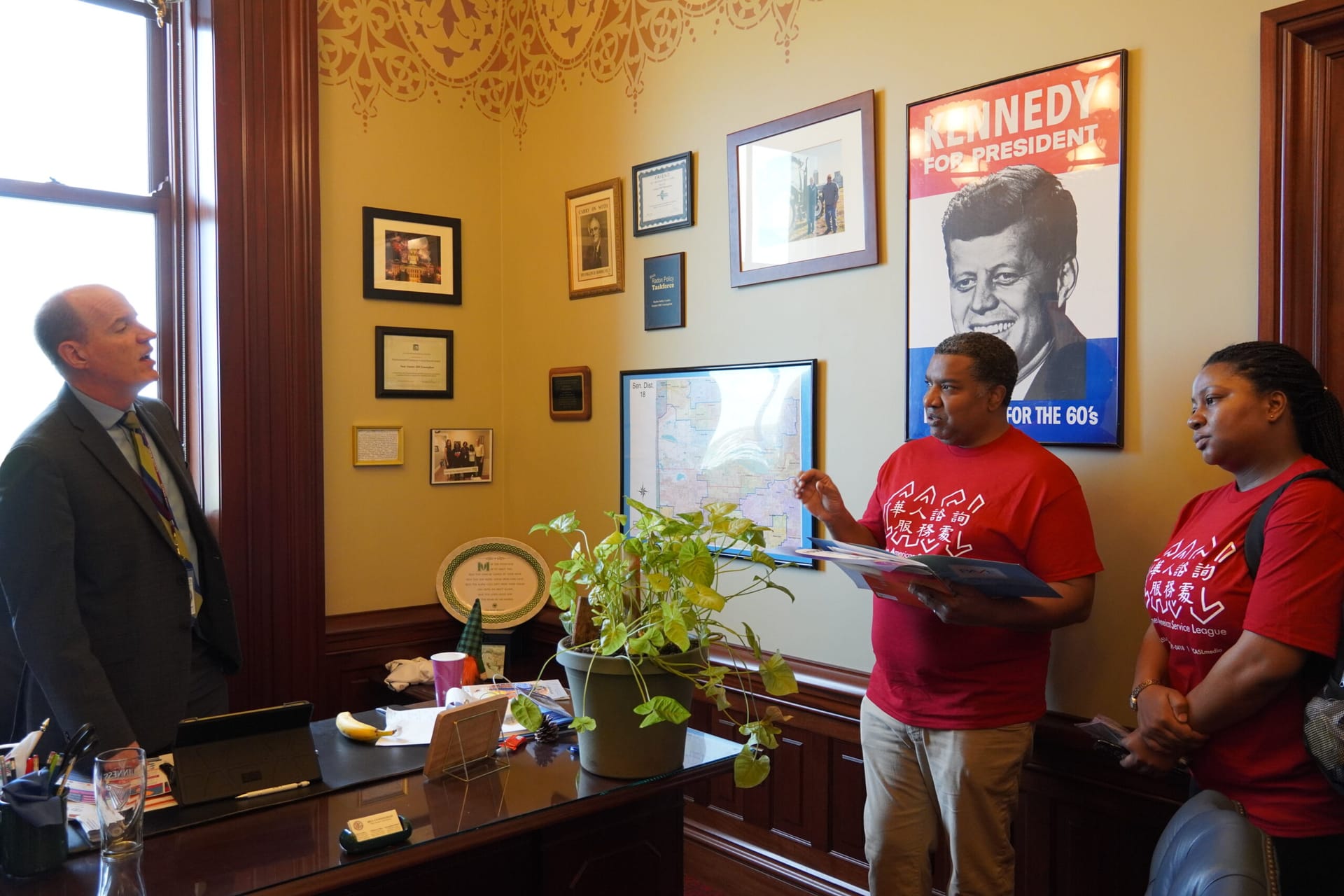 Two people wearing CASL T-shirts in an office.