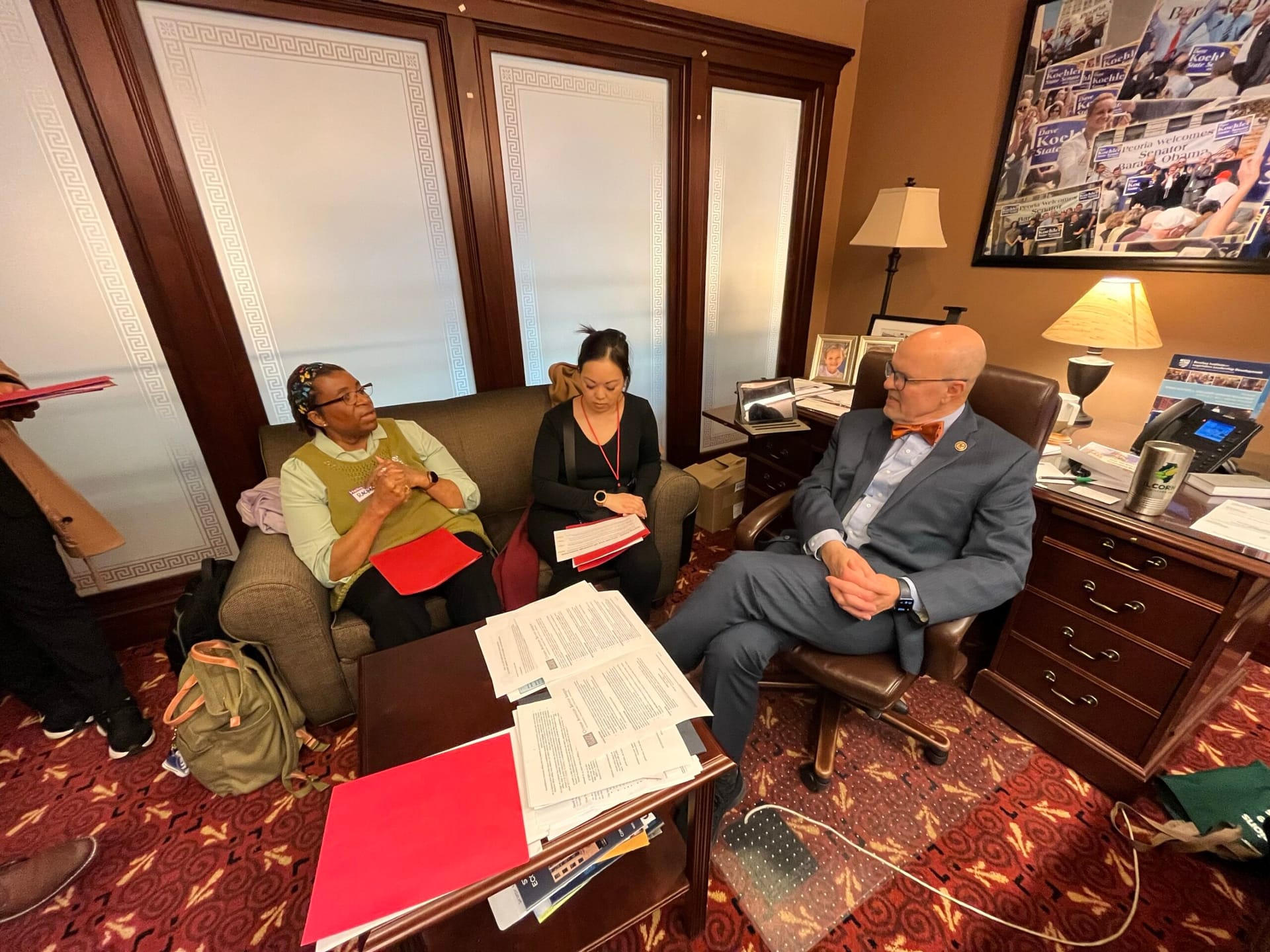 Three adults in a meeting.