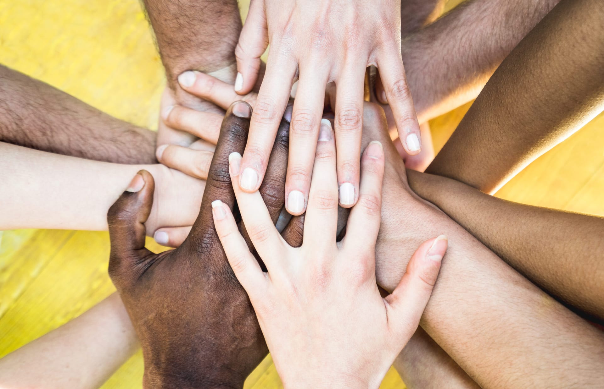 Multi-racial hands stacked together.