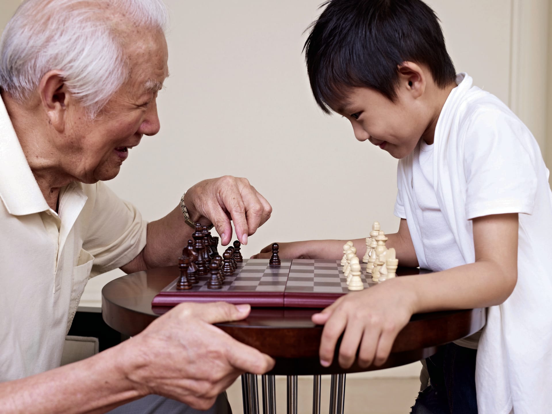 Grandfather playing chess with grandson.
