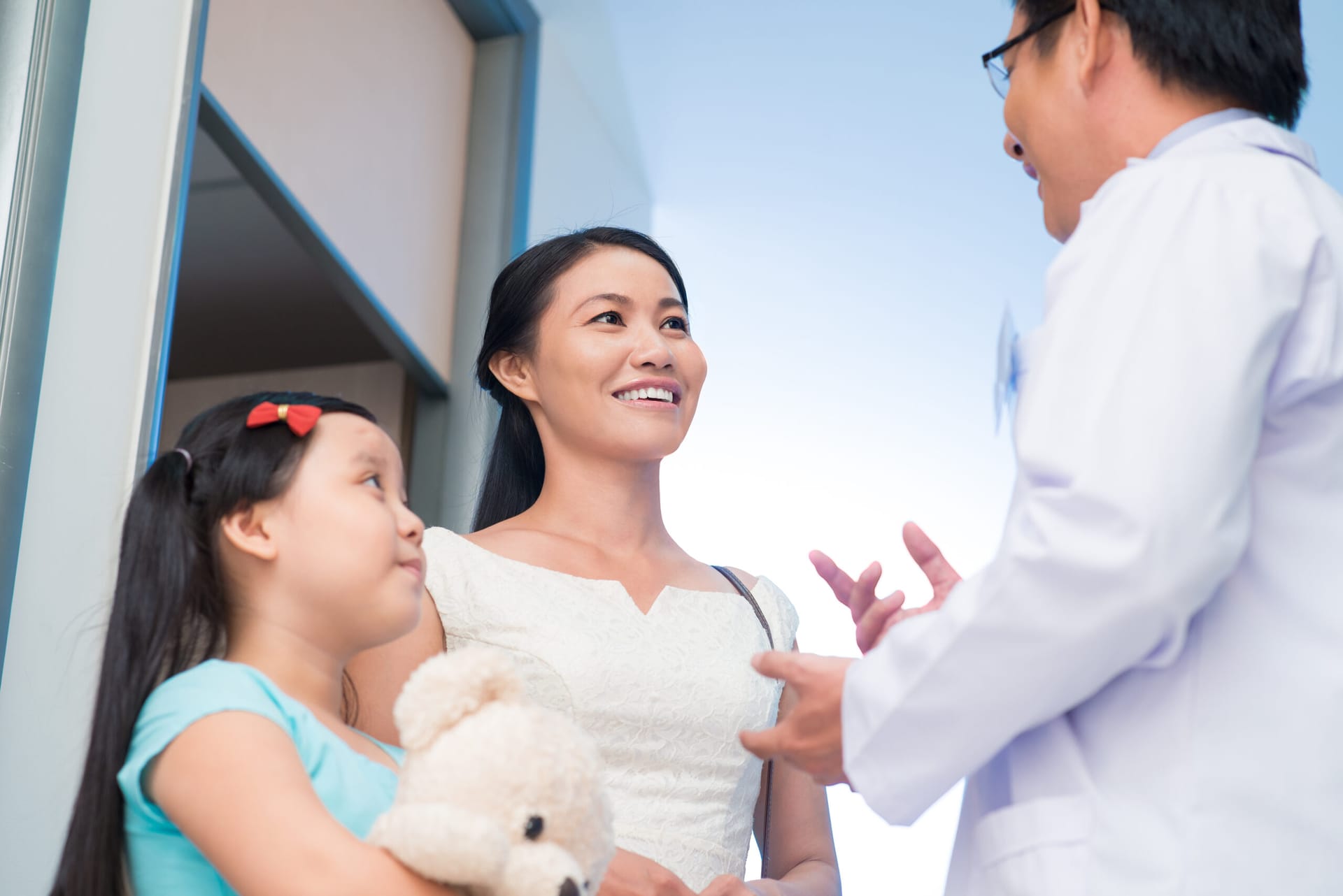 Asian mother and child peaking with an Asian pediatrician.