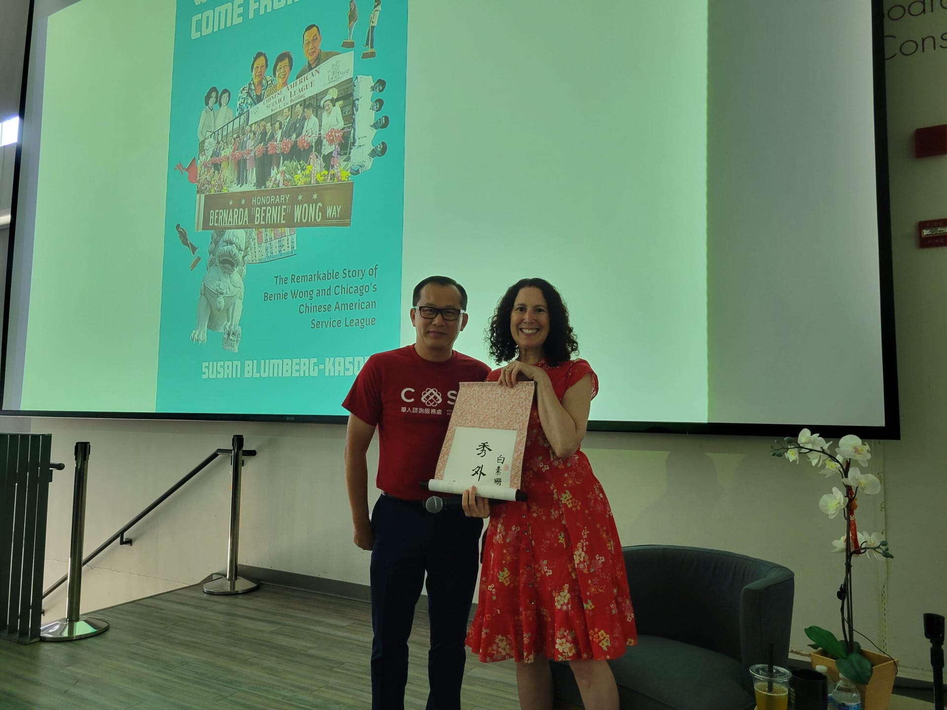 Susan Blumberg Kason and Paul Luu hold a book