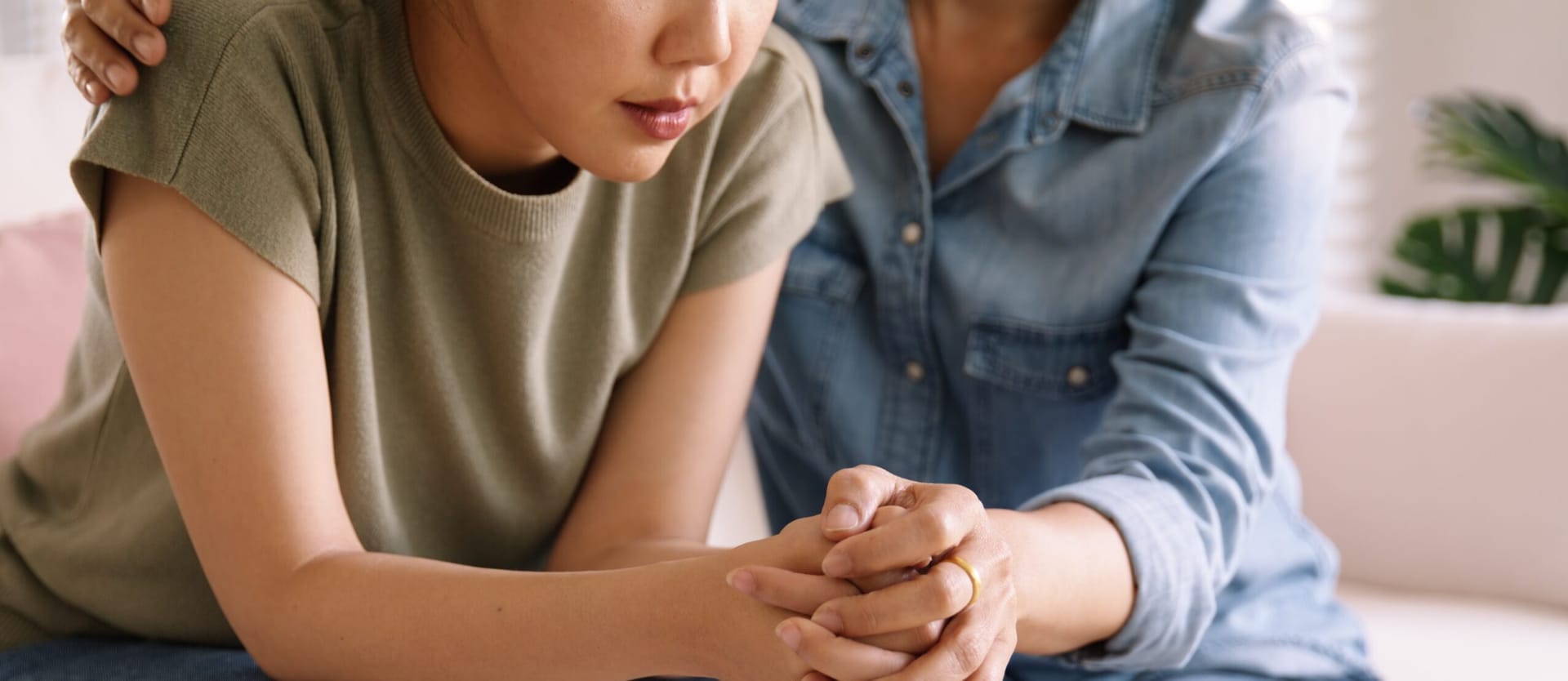 One Asian woman comforting another