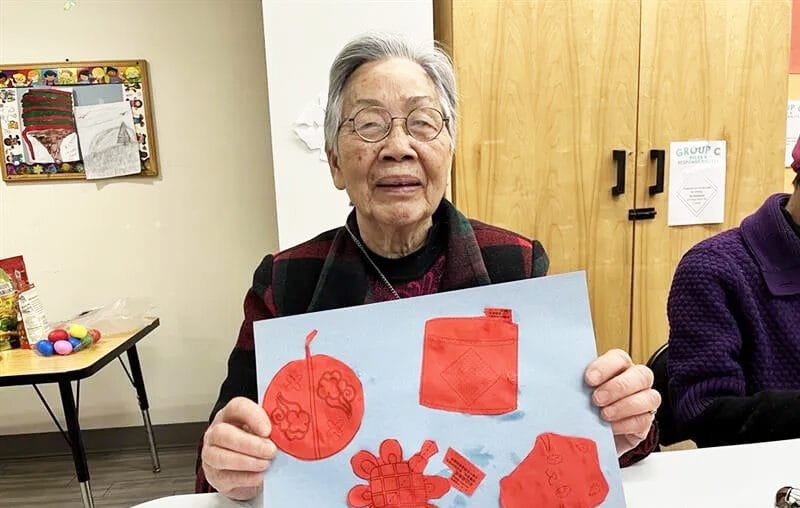 CASL older adult showing her artwork
